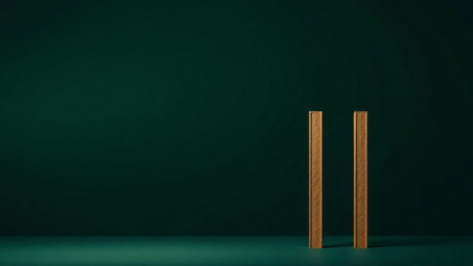 Dos reglas doradas de pie sobre un piso verde oscuro, en orden